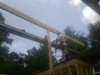 Carpenter setting a ridge beam over a new addition frame — Ice Dam Removal by Roofing Brothers in Fort Howard