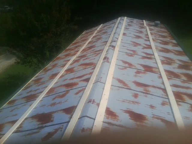 Rusted metal roof panels with new wood purlins before replacement — Storm Damage Roof Repair in Fort Howard by Roofing Brothers