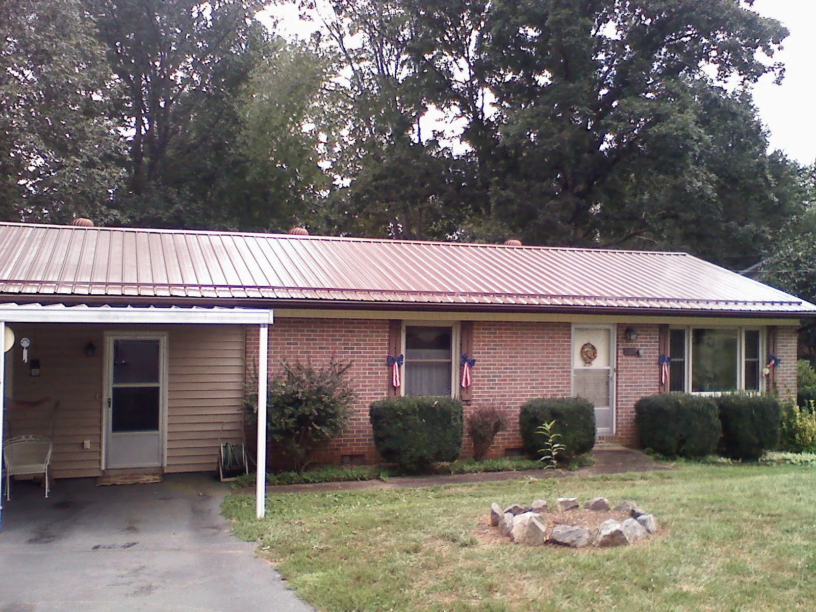 Bronze metal roof and carport on a brick ranch home — Roof Repair work by our crew in Fort Howard