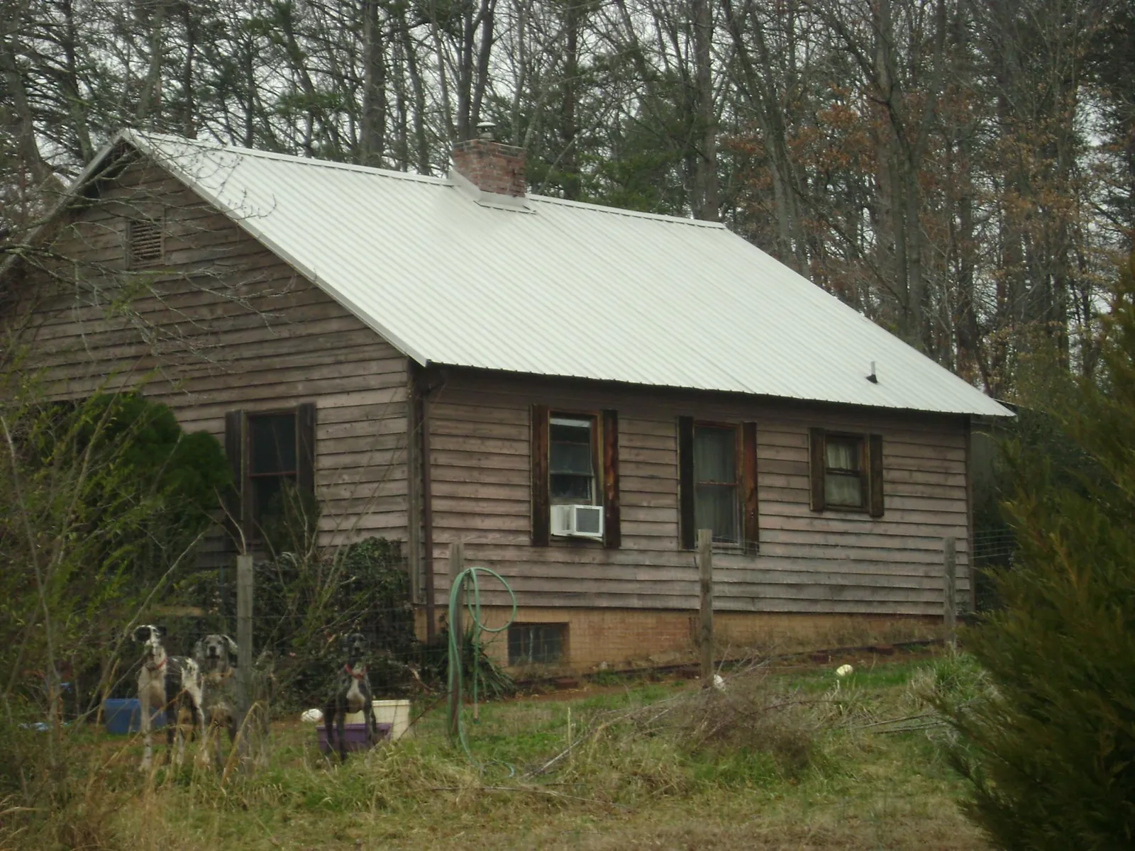 White metal roof on an old wood sided farmhouse, from a Metal Roof Installation job in Fort Howard